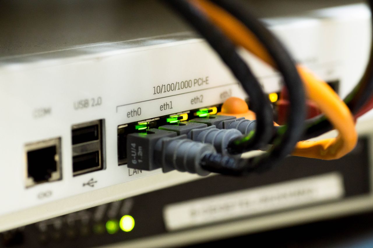 journey Detailed close-up of ethernet cables and network connections on a router, showcasing modern technology.